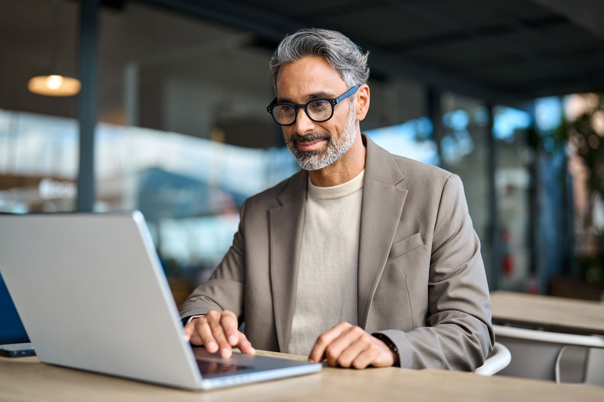 smiling-mature-business-man-entrepreneur-using-laptop